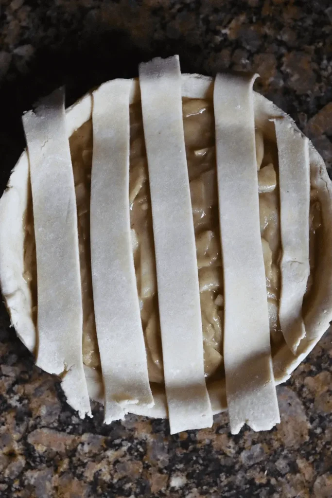 After rolling out the dough fully, add more flour to your work surface to prevent sticking. Flip the dough over and roll it out again until it's nice and thin, approximately 1/8 inch thick and shaped into a 12-inch circle.