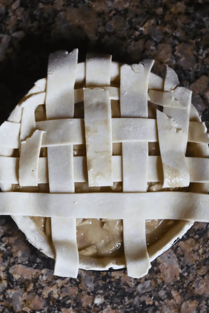 After rolling out the dough fully, add more flour to your work surface to prevent sticking. Flip the dough over and roll it out again until it's nice and thin, approximately 1/8 inch thick and shaped into a 12-inch circle.