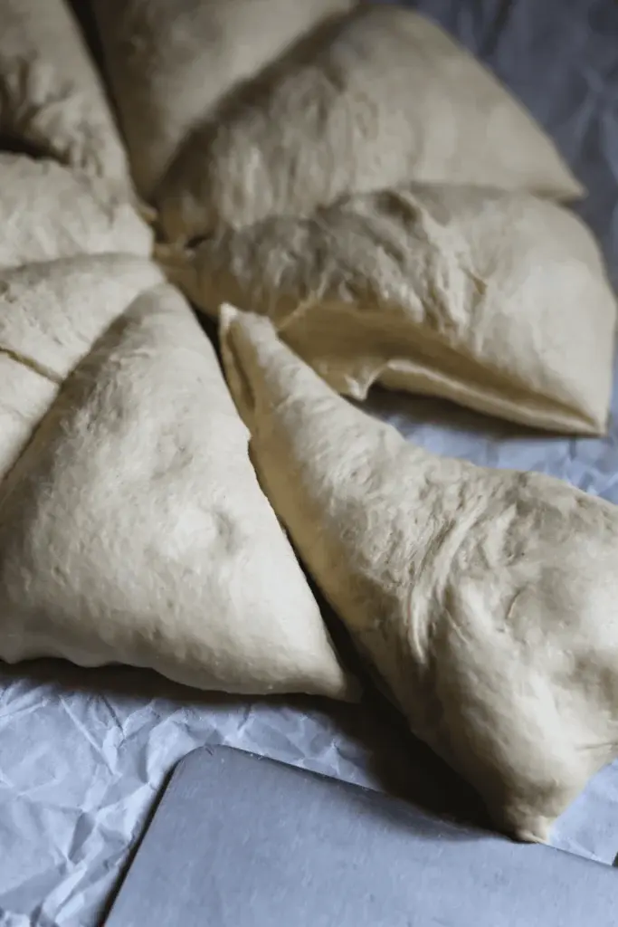 Step 7: Stretch and mold the dough into a big rectangle, roughly 1/2 inch thick. Using a bench scraper or a sharp knife, slice the dough into 8 equal triangle pieces (around 115g each).