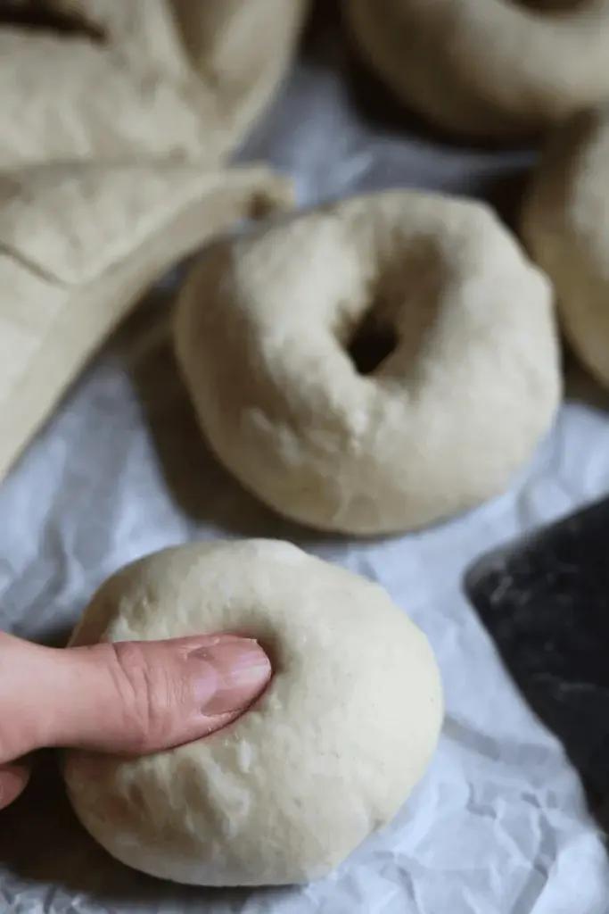 Step 8: To shape it, take a piece of dough and pull the corners of the triangles into the center. After that, roll the dough until it becomes a smooth ball. Do the same with the other pieces of dough.